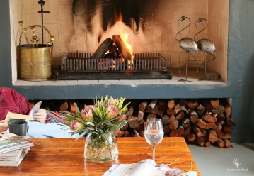 Reading by the fire at India House, Bastiaanskloof Reserve